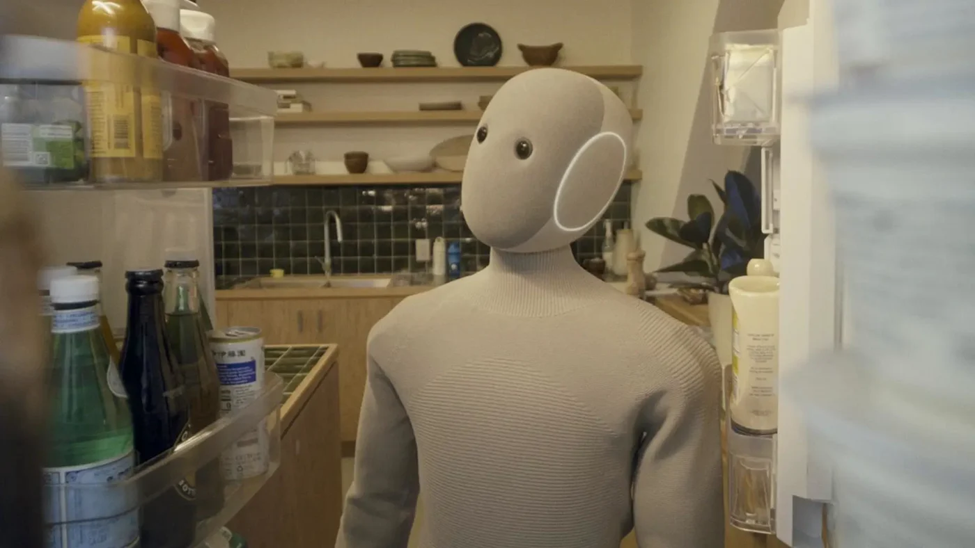 Current beige NEO beside an open refrigerator in a domestic kitchen.