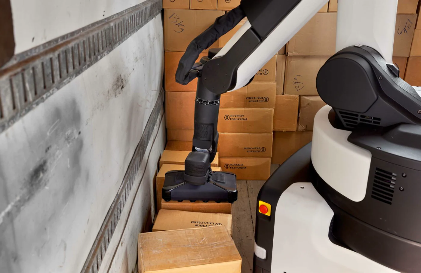 Recovery of a dropped case: Stretch reaches down with its vacuum gripper to pick a box from the trailer floor.
