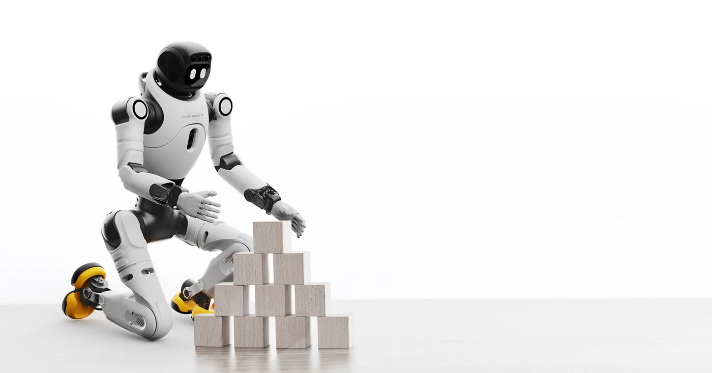 Crouched X2 robot next to a stack of small objects.