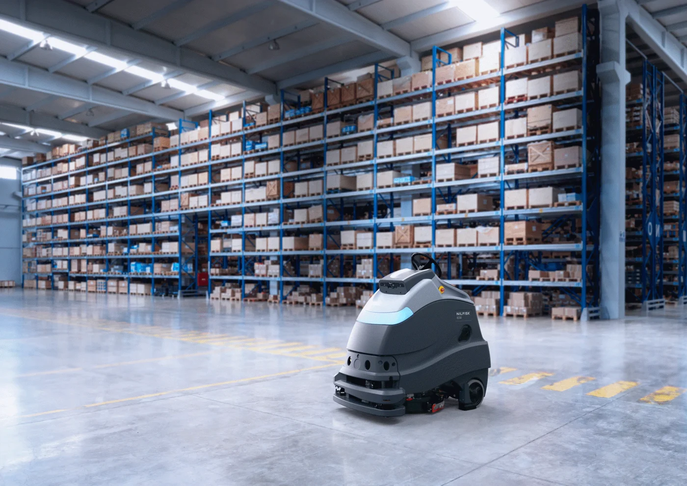 Autonomous floor scrubber working across a large warehouse floor